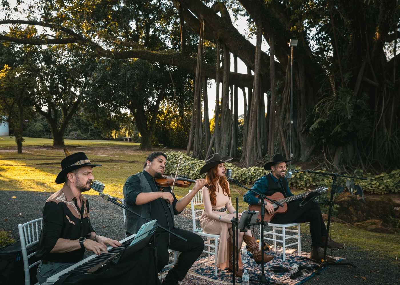 Quarteto de chapéu tocando a cerimônia sob as árvores